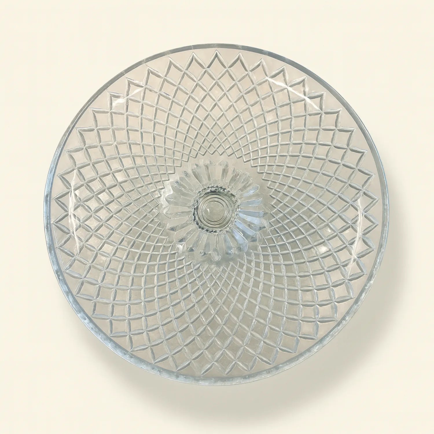 Clear glass plate with diamond pattern on a beige background