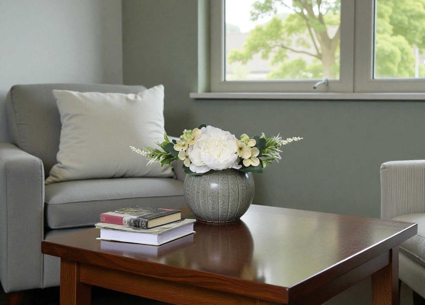 Living room with a gray sofa, wooden coffee table, and a vase of flowers.