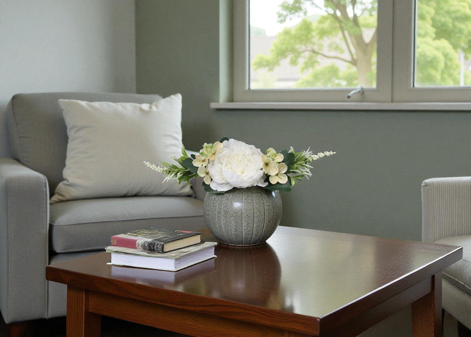 Living room with a gray sofa, wooden coffee table, and a vase of flowers.