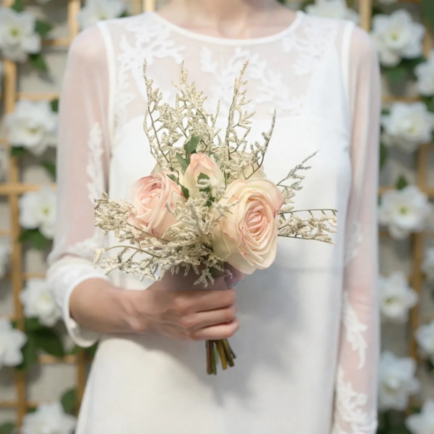 Person holding a bouquet of flowers against a floral backdrop